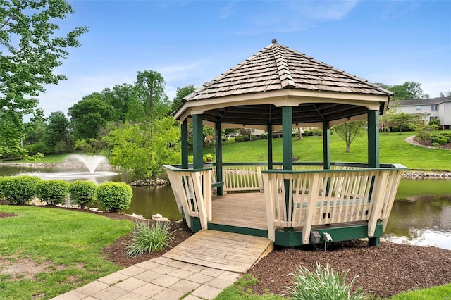 view of dock with a lawn, a water view, and a gazebo