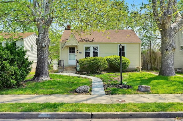 view of front facade featuring a front lawn and a chimney