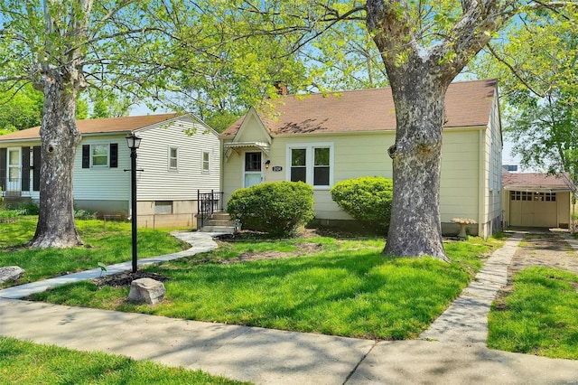 view of front of house with a front lawn and an outbuilding