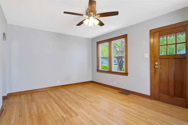 entrance foyer featuring plenty of natural light, arched walkways, light wood-style floors, and visible vents