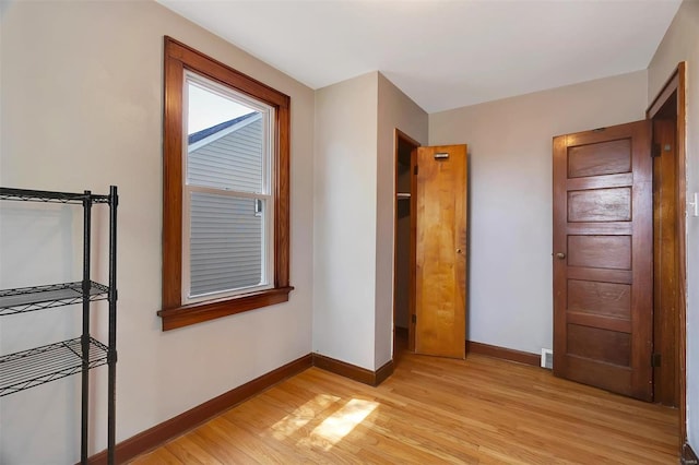 unfurnished bedroom with baseboards, visible vents, and light wood-type flooring