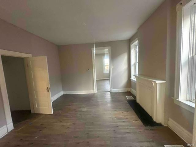 interior space with baseboards, visible vents, and wood finished floors
