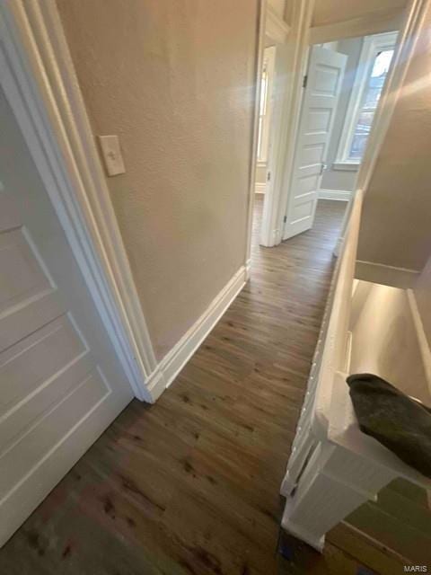 hallway with baseboards and wood finished floors