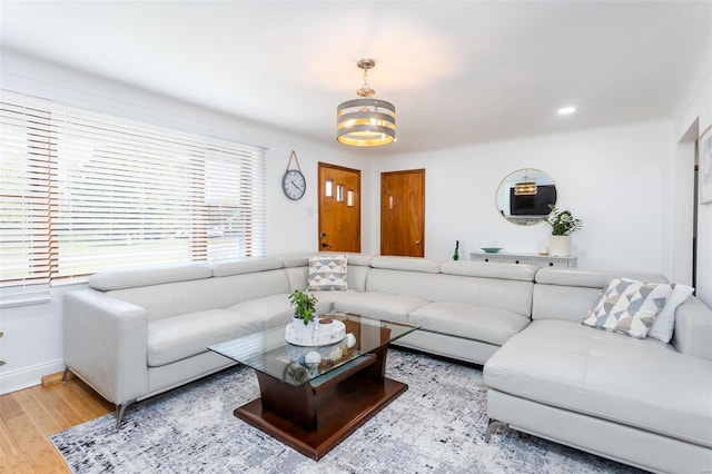 living room with baseboards, a chandelier, and wood finished floors