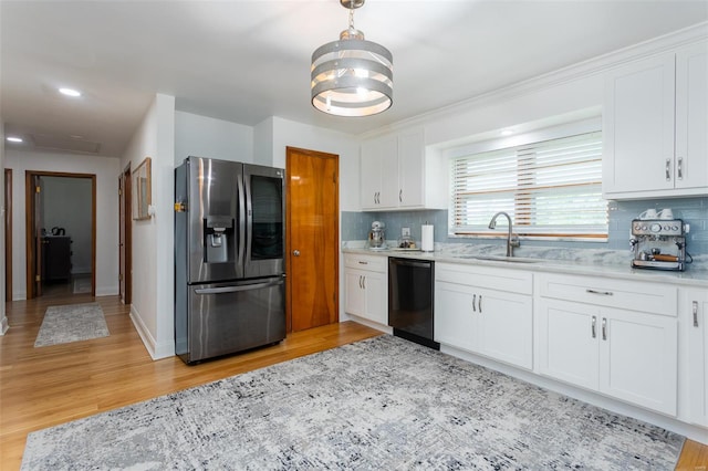 kitchen with white cabinets, stainless steel fridge, a sink, black dishwasher, and backsplash