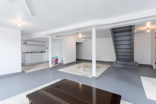 finished below grade area featuring stairway and baseboards