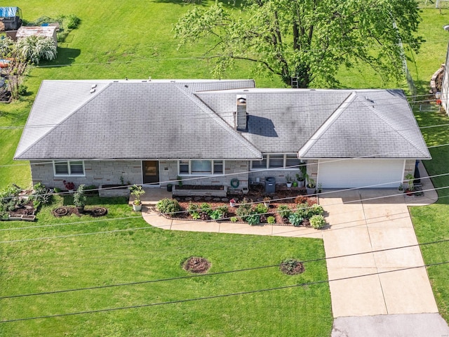 view of front of house featuring driveway, a chimney, and a front lawn