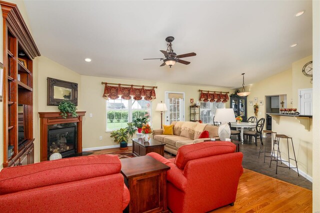 living room with wood finished floors, baseboards, recessed lighting, a high end fireplace, and a ceiling fan