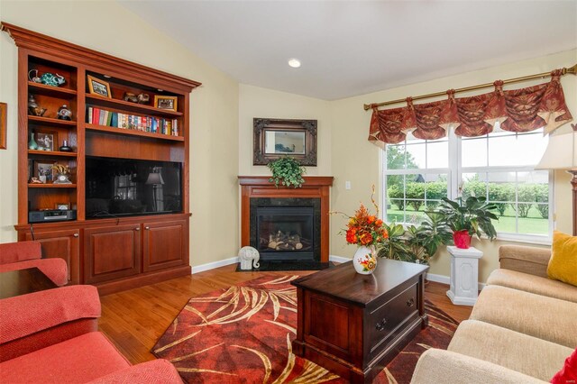 living area with recessed lighting, dark wood finished floors, baseboards, and a fireplace