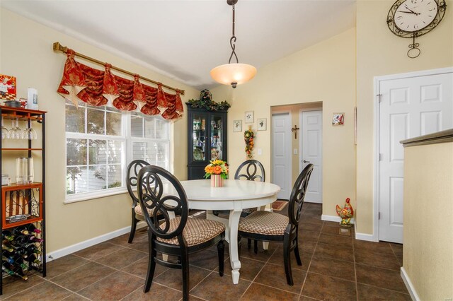 dining room featuring dark tile patterned flooring and baseboards