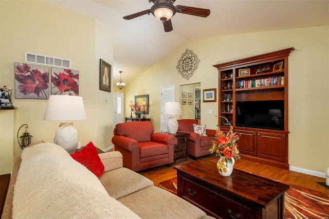 living area featuring ceiling fan, baseboards, wood finished floors, vaulted ceiling, and visible vents