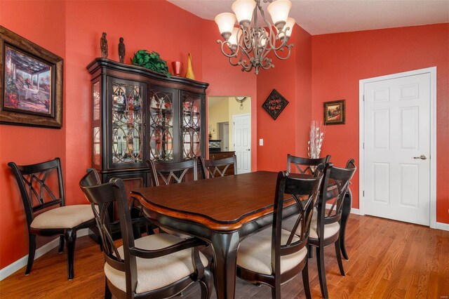 dining area with an inviting chandelier, baseboards, and wood finished floors