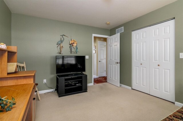 carpeted bedroom featuring baseboards, visible vents, and a closet