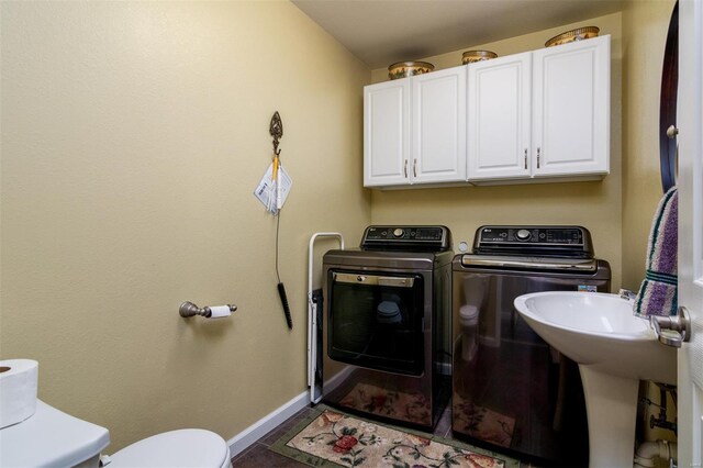 laundry room with baseboards, laundry area, and washer and clothes dryer