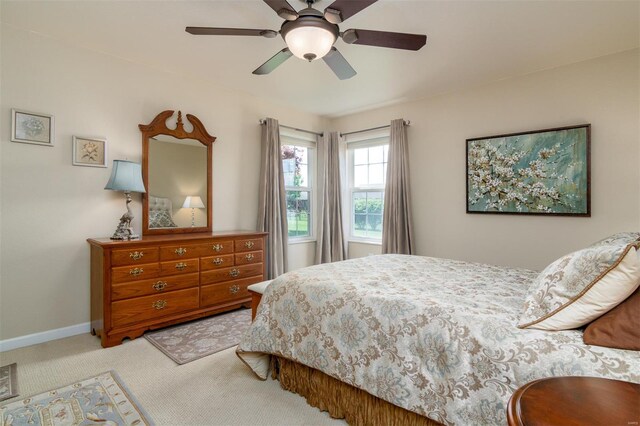 carpeted bedroom with baseboards and a ceiling fan