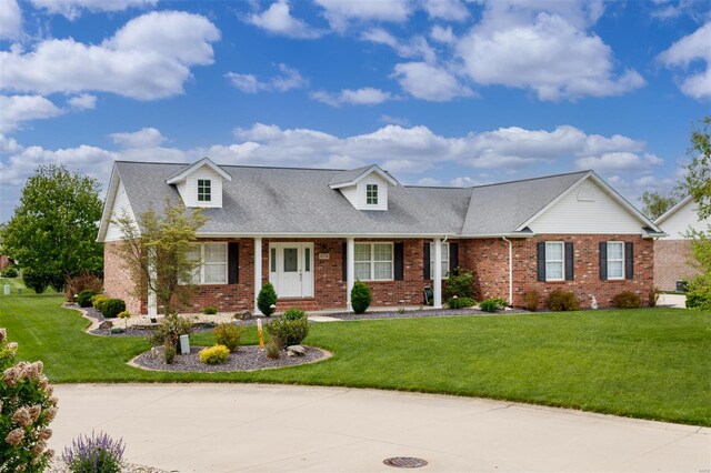 cape cod house with brick siding and a front yard