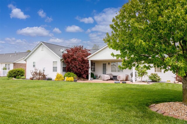 rear view of property featuring a yard