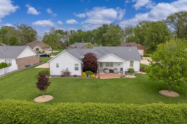 back of property featuring a lawn, fence, and a patio area