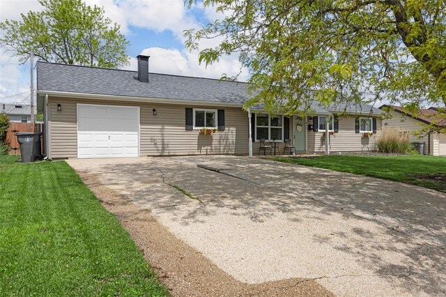 single story home featuring a garage, a front lawn, a chimney, and concrete driveway