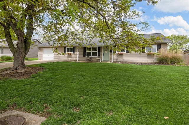 ranch-style home with roof with shingles, an attached garage, concrete driveway, and a front lawn