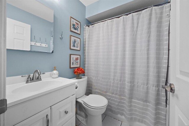 bathroom featuring vanity, a shower with shower curtain, tile patterned floors, and toilet