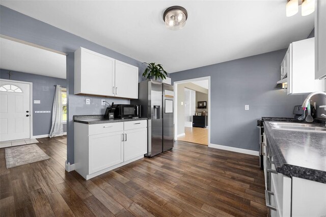 kitchen featuring dark countertops, black microwave, and baseboards