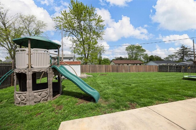 view of playground with a fenced backyard and a lawn