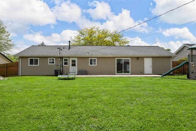back of property with a lawn, fence, and a patio