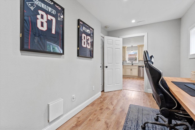 home office featuring visible vents, baseboards, recessed lighting, a sink, and light wood-style flooring