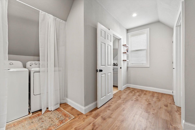 laundry area with baseboards, laundry area, light wood-type flooring, and washer and clothes dryer