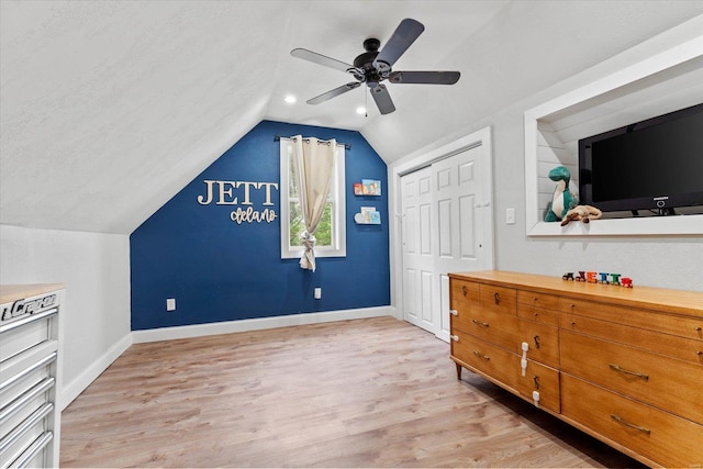 bedroom featuring a closet, baseboards, ceiling fan, light wood-style flooring, and vaulted ceiling
