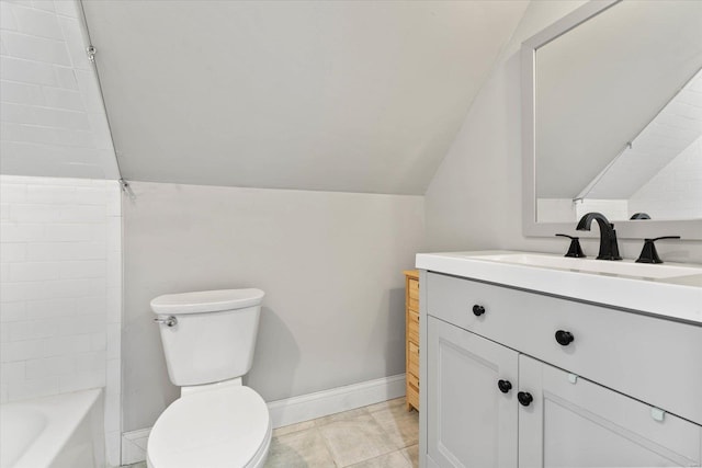 bathroom with baseboards, vanity, toilet, and lofted ceiling