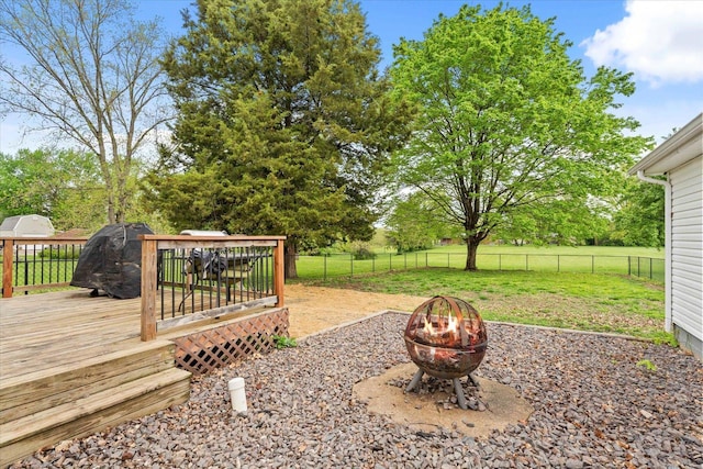 view of yard with a fenced backyard, a fire pit, and a wooden deck