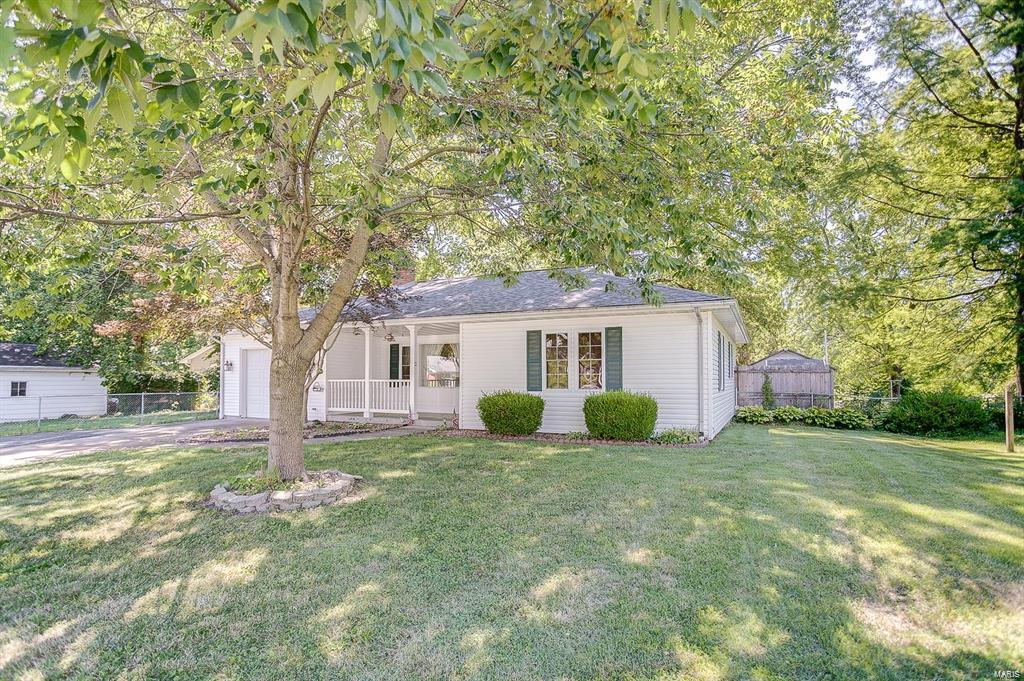 single story home featuring a front lawn, fence, and covered porch
