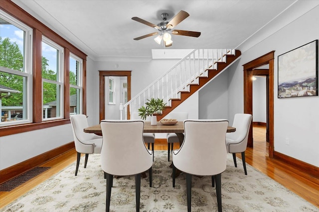 dining area featuring stairway, light wood finished floors, baseboards, and visible vents