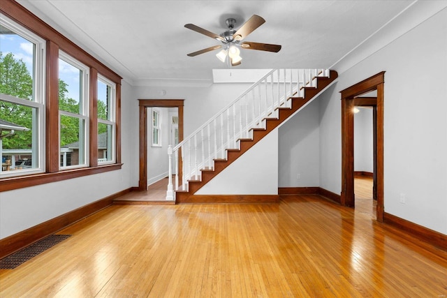 unfurnished living room featuring baseboards, ceiling fan, light wood finished floors, and visible vents
