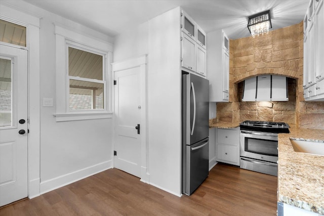 kitchen featuring stainless steel appliances, tasteful backsplash, dark wood-style floors, and white cabinets