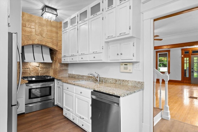 kitchen with white cabinets, appliances with stainless steel finishes, dark wood-style floors, and a sink