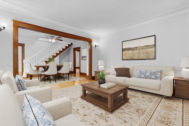 living room with stairway, crown molding, and wood finished floors