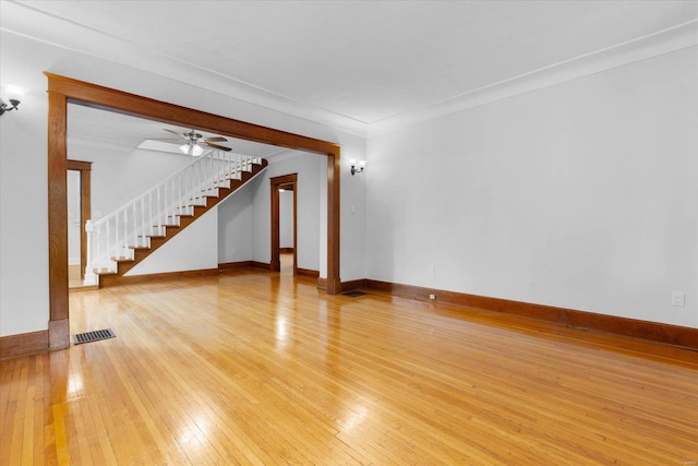 unfurnished living room featuring visible vents, stairway, ceiling fan, baseboards, and light wood-style floors