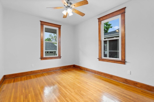empty room with ceiling fan, baseboards, and wood-type flooring