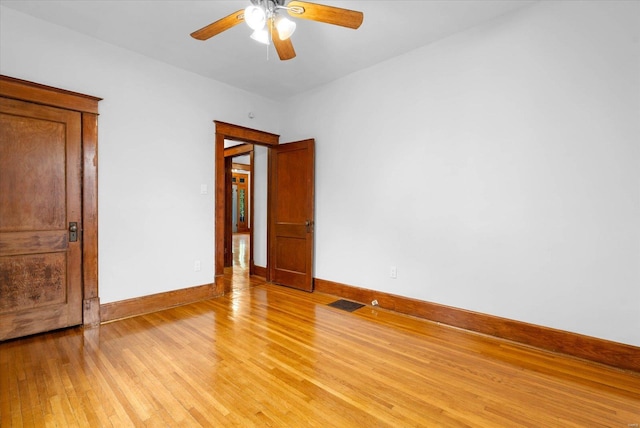 unfurnished room with baseboards, visible vents, light wood-style flooring, and ceiling fan