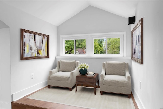 sitting room with vaulted ceiling, baseboards, and plenty of natural light