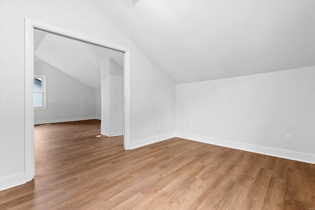 bonus room featuring vaulted ceiling, wood finished floors, and baseboards