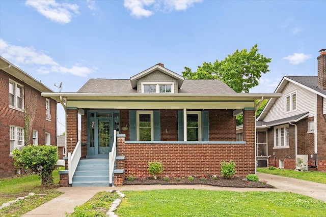 bungalow-style home featuring covered porch and brick siding