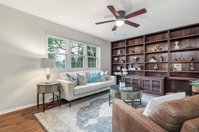 living room with baseboards, ceiling fan, and wood finished floors