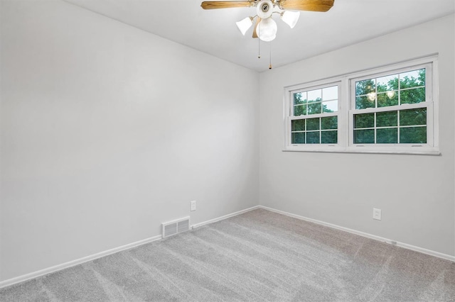 empty room featuring visible vents, carpet flooring, baseboards, and ceiling fan