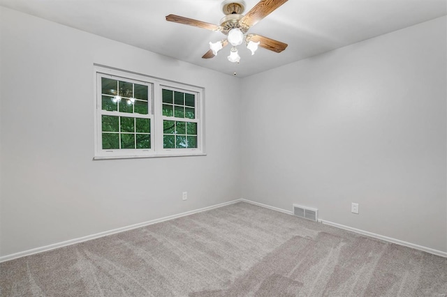 carpeted empty room featuring baseboards, a ceiling fan, and visible vents