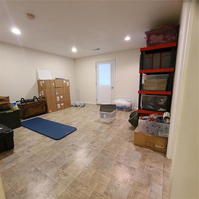 exercise area featuring recessed lighting and stone tile floors