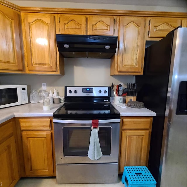 kitchen with light countertops, appliances with stainless steel finishes, brown cabinetry, and under cabinet range hood